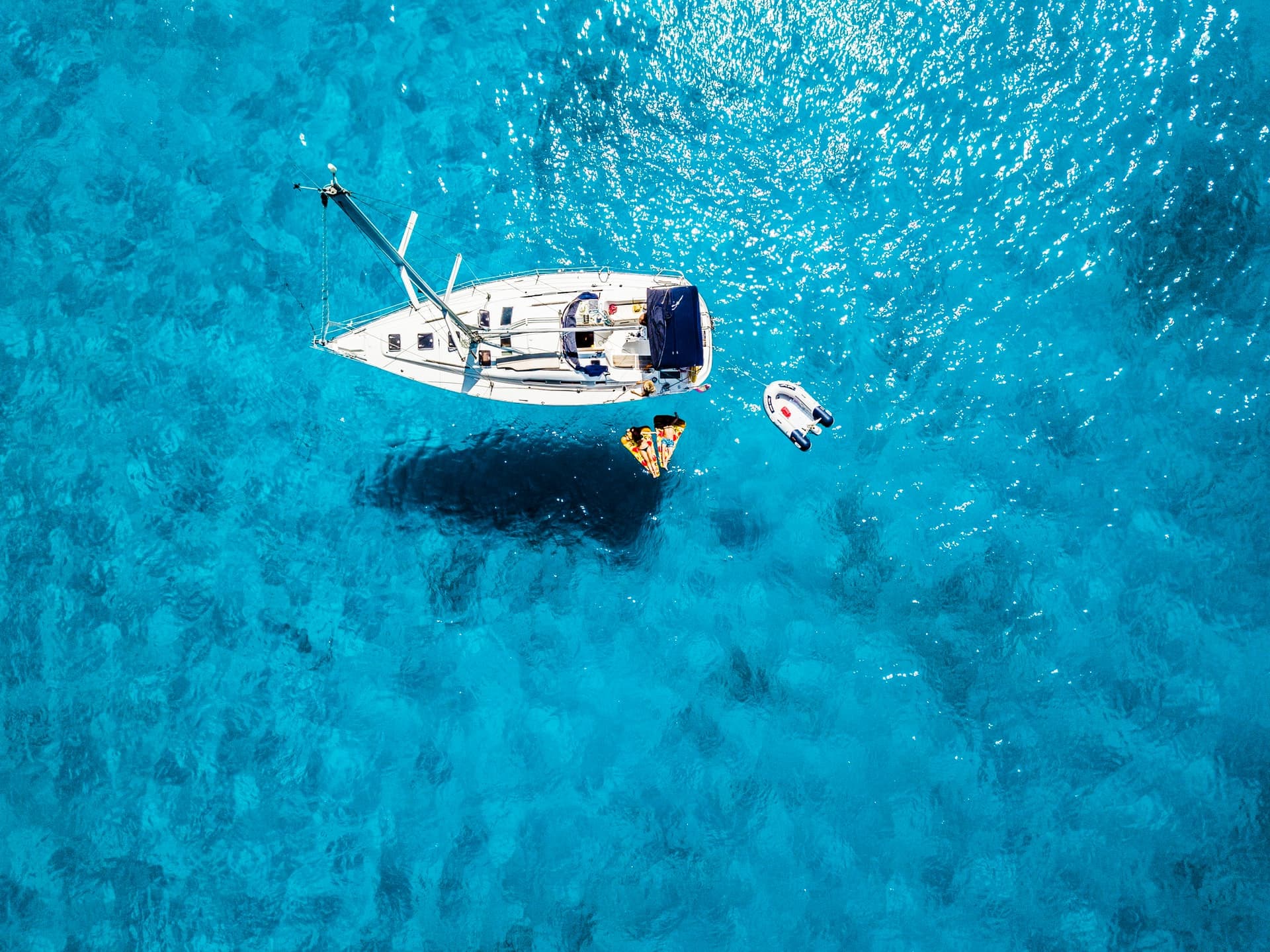 Aerial view of a sailboat on turquoise water representing retirement freedom