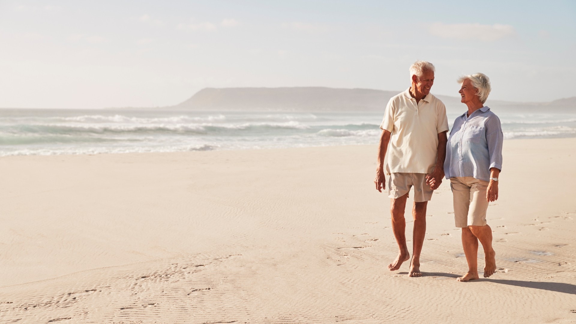 Retired couple walking on the beach